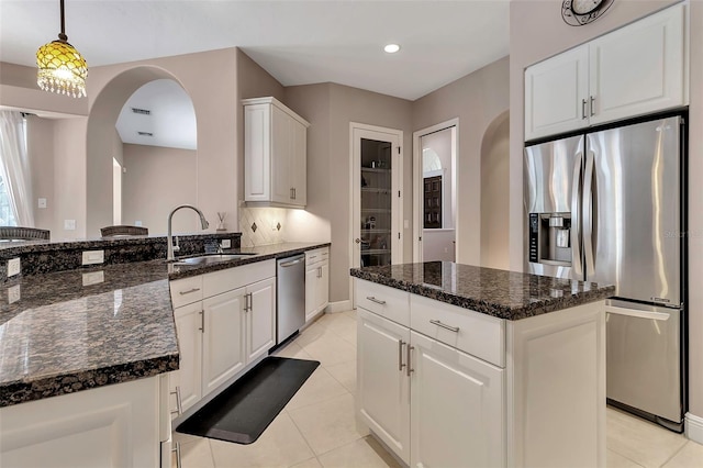 3738 Eagle Hammock Dr, Sarasota, FL 34240 - kitchen with stainless steel appliances, arched walkways, a sink, and light tile patterned flooring