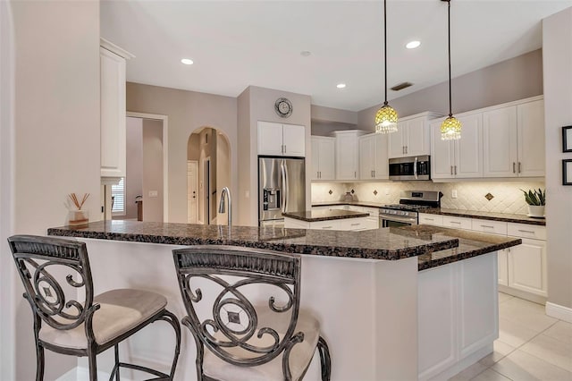 3738 Eagle Hammock Dr, Sarasota, FL 34240 - kitchen featuring stainless steel appliances, a breakfast bar, visible vents, decorative backsplash, and a peninsula