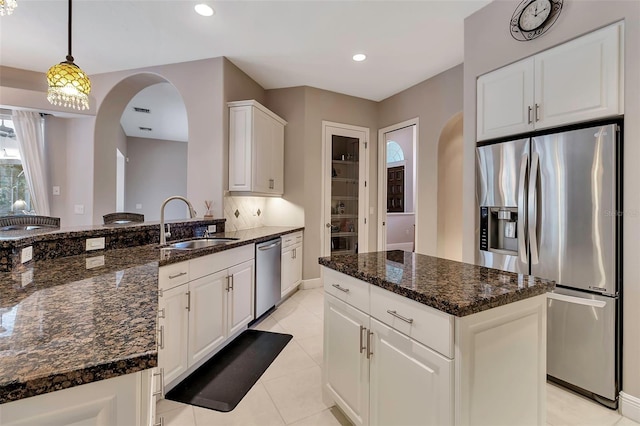 3738 Eagle Hammock Dr, Sarasota, FL 34240 - kitchen featuring arched walkways, white cabinetry, stainless steel appliances, and a sink