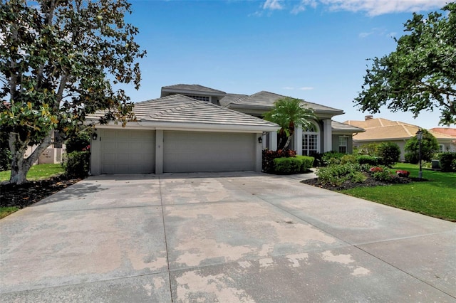3738 Eagle Hammock Dr, Sarasota, FL 34240 - view of front of house featuring a tiled roof, driveway, an attached garage, a front yard, and stucco siding