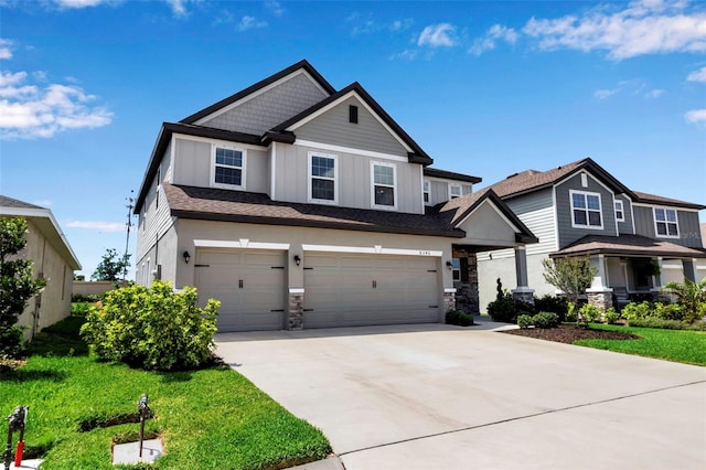 craftsman inspired home featuring a garage, a front lawn, driveway, and stone siding