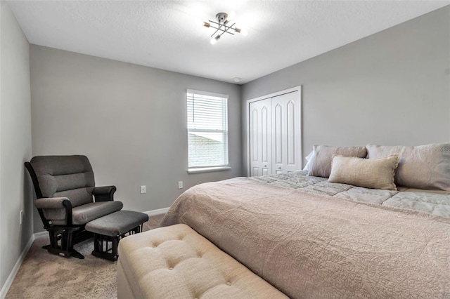 carpeted bedroom featuring baseboards and a closet