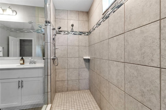 full bathroom featuring a tile shower and vanity