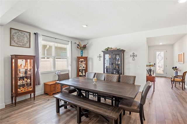 7322 34th Ct E, Sarasota, FL 34243 - dining room featuring light wood finished floors, recessed lighting, a textured ceiling, and baseboards