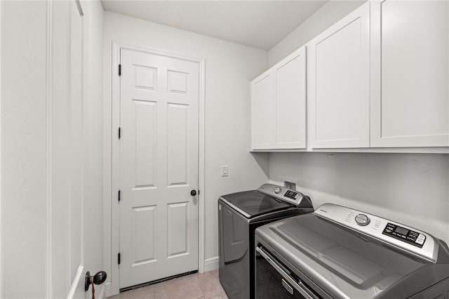 7322 34th Ct E, Sarasota, FL 34243 - laundry room featuring washer and dryer, cabinet space, light tile patterned floors, and baseboards