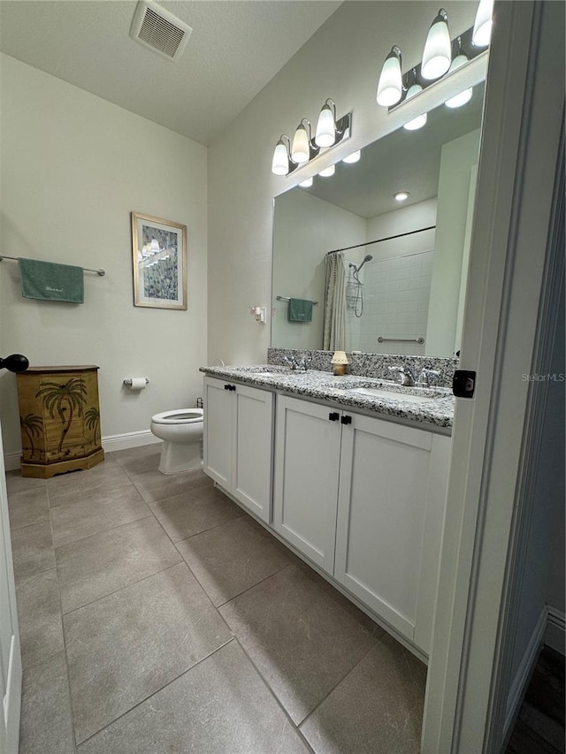 7322 34th Ct E, Sarasota, FL 34243 - full bath with a tile shower, toilet, baseboards, and double vanity