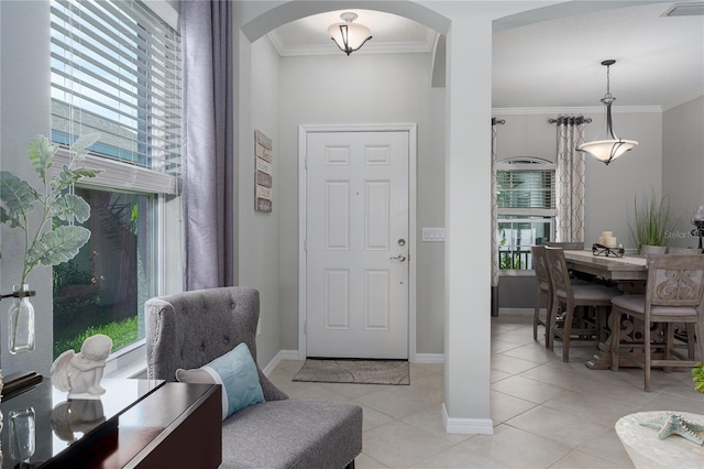 entryway featuring visible vents, arched walkways, light tile patterned flooring, crown molding, and baseboards
