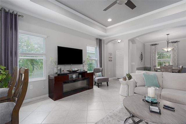 living area with arched walkways, a healthy amount of sunlight, a ceiling fan, and light tile patterned floors
