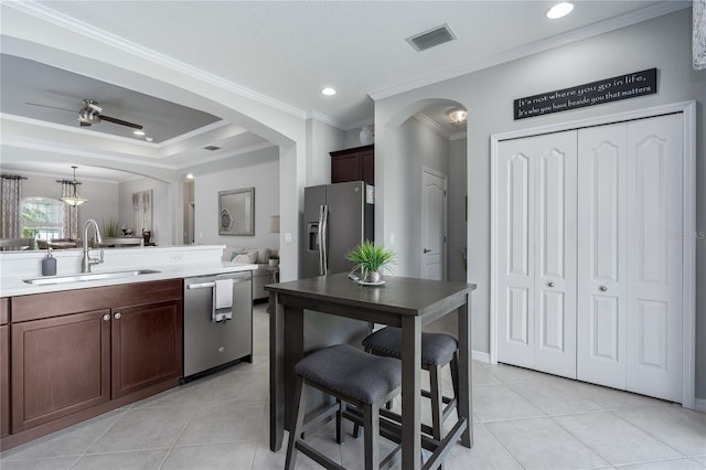 kitchen featuring arched walkways, visible vents, appliances with stainless steel finishes, and a sink