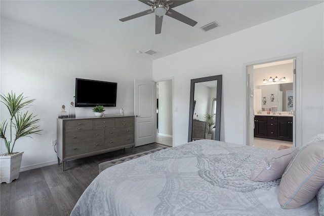 bedroom featuring wood finished floors, ensuite bathroom, ceiling fan, baseboards, and visible vents