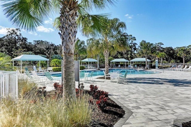 community pool with fence and a patio area
