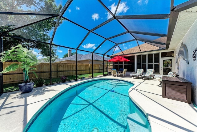 view of pool with fence, a patio, glass enclosure, and a fenced in pool