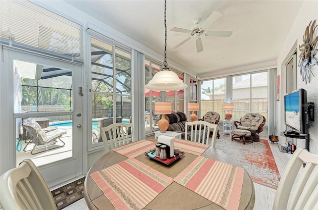 sunroom / solarium featuring ceiling fan and outdoor dining space