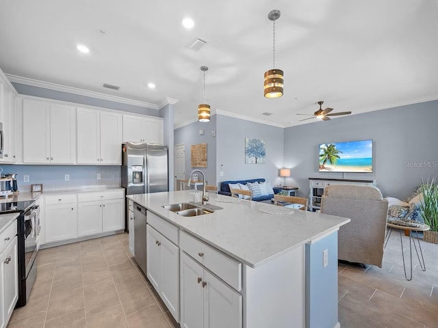 kitchen with a sink, stainless steel appliances, ornamental molding, open floor plan, and ceiling fan