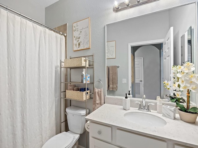 full bath featuring vanity, toilet, and curtained shower
