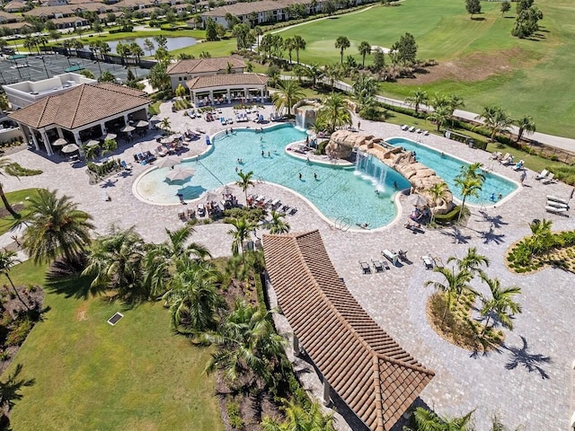 drone / aerial view of a pool, a golf club, and a large body of water