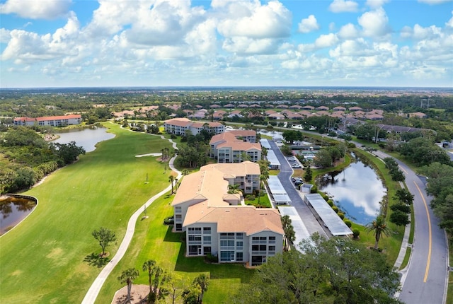 drone / aerial view with a water view and golf course view