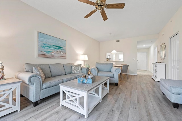 living room featuring a ceiling fan, baseboards, visible vents, and light wood finished floors
