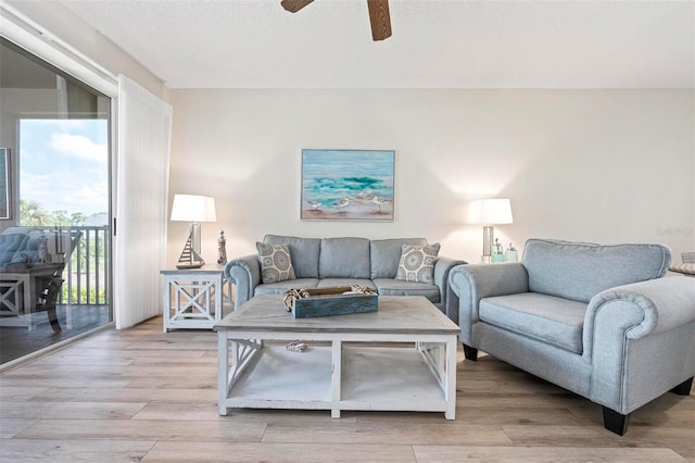 living room with ceiling fan and light wood-style flooring