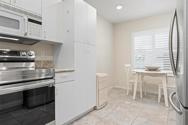kitchen with white cabinets, stainless steel appliances, baseboards, and recessed lighting