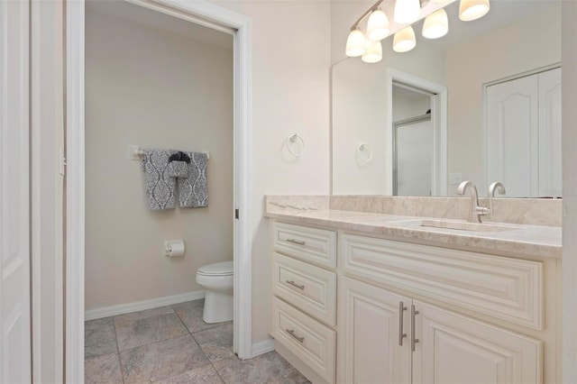 bathroom featuring an enclosed shower, vanity, baseboards, and toilet