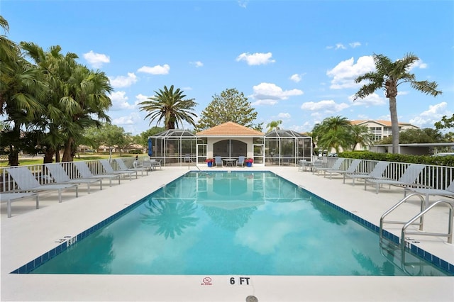 community pool with glass enclosure and a patio