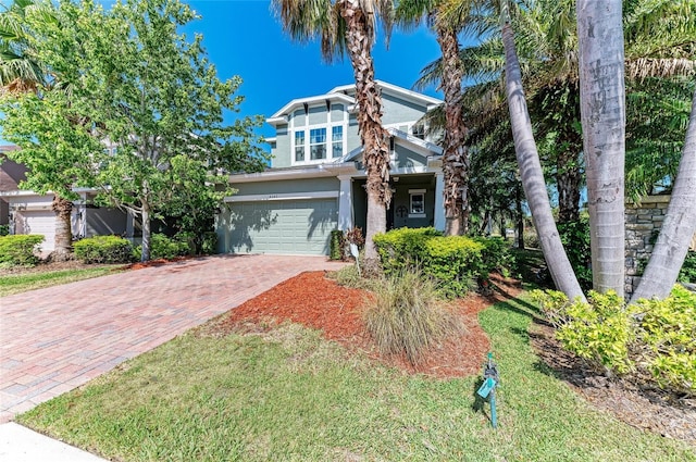 obstructed view of property featuring stucco siding, an attached garage, and decorative driveway