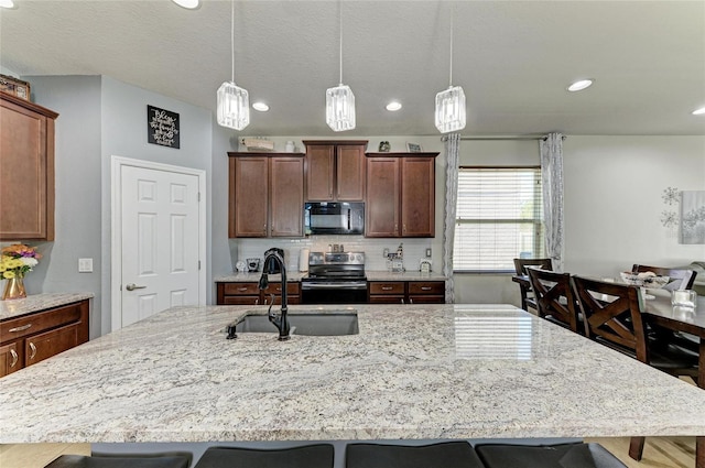 kitchen with stainless steel electric stove, a kitchen breakfast bar, black microwave, and a sink