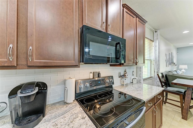 kitchen featuring backsplash, black microwave, stainless steel electric range oven, light stone countertops, and recessed lighting