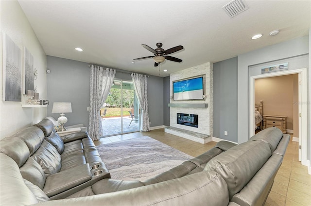tiled living area with visible vents, a ceiling fan, recessed lighting, and a stone fireplace