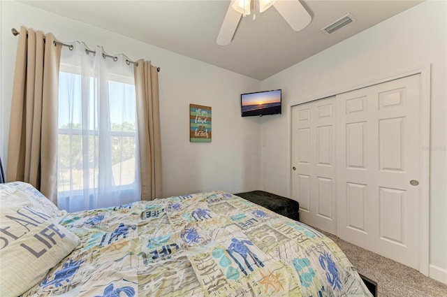 carpeted bedroom featuring vaulted ceiling, ceiling fan, a closet, and visible vents