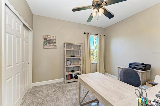 office space featuring light colored carpet, baseboards, and ceiling fan