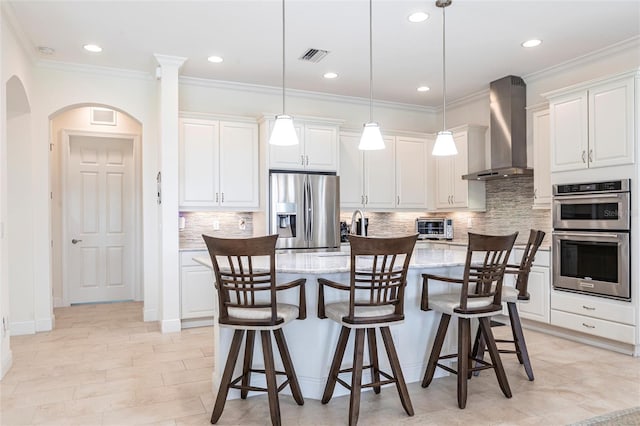 5502 Tidewater Preserve Blvd, Bradenton, FL 34208 - kitchen with wall chimney exhaust hood, appliances with stainless steel finishes, arched walkways, tasteful backsplash, and recessed lighting