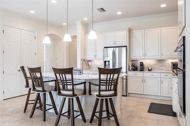 5502 Tidewater Preserve Blvd, Bradenton, FL 34208 - kitchen with stainless steel fridge, crown molding, a sink, white cabinets, and tasteful backsplash