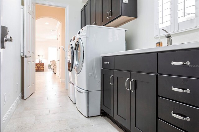 5502 Tidewater Preserve Blvd, Bradenton, FL 34208 - washroom with cabinet space, separate washer and dryer, arched walkways, and baseboards