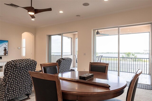 5502 Tidewater Preserve Blvd, Bradenton, FL 34208 - dining room featuring a ceiling fan, carpet flooring, plenty of natural light, arched walkways, and crown molding