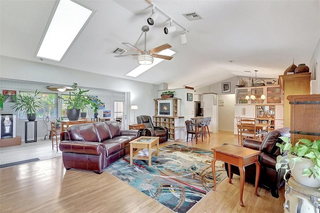 519 Bayview Ave, Osprey, FL 34229 - living area with a ceiling fan, a skylight, track lighting, vaulted ceiling, and light wood finished floors