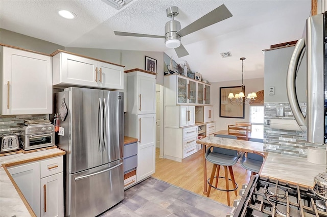 519 Bayview Ave, Osprey, FL 34229 - kitchen featuring freestanding refrigerator, ceiling fan, tasteful backsplash, a chandelier, and white cabinetry