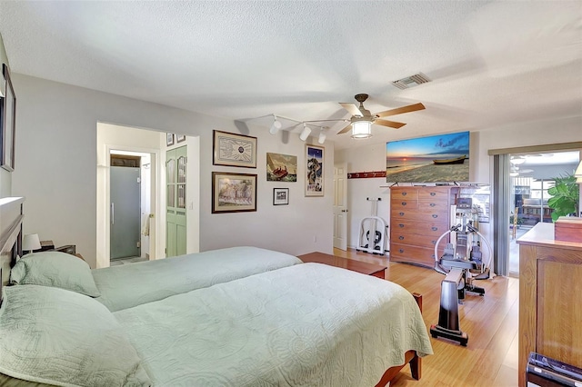 519 Bayview Ave, Osprey, FL 34229 - bedroom with light wood-style floors, a textured ceiling, and a ceiling fan
