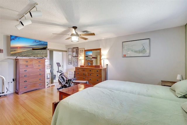519 Bayview Ave, Osprey, FL 34229 - bedroom featuring light wood finished floors, a textured ceiling, track lighting, and a ceiling fan