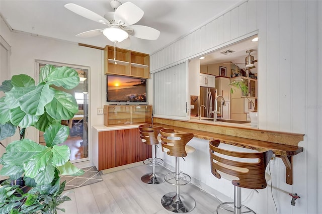 519 Bayview Ave, Osprey, FL 34229 - bar with a sink, wood finished floors, ceiling fan, and freestanding refrigerator