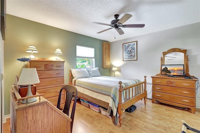 519 Bayview Ave, Osprey, FL 34229 - bedroom with a textured ceiling, a ceiling fan, and light wood-style flooring