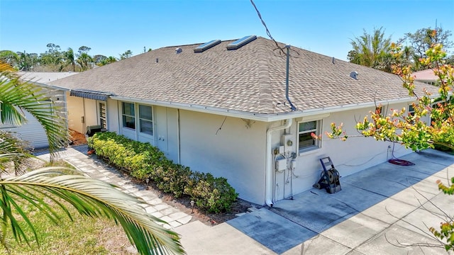 519 Bayview Ave, Osprey, FL 34229 - view of property exterior with roof with shingles, stucco siding, and a patio area