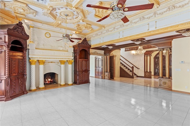 unfurnished living room with ornate columns, ceiling fan, crown molding, and baseboards