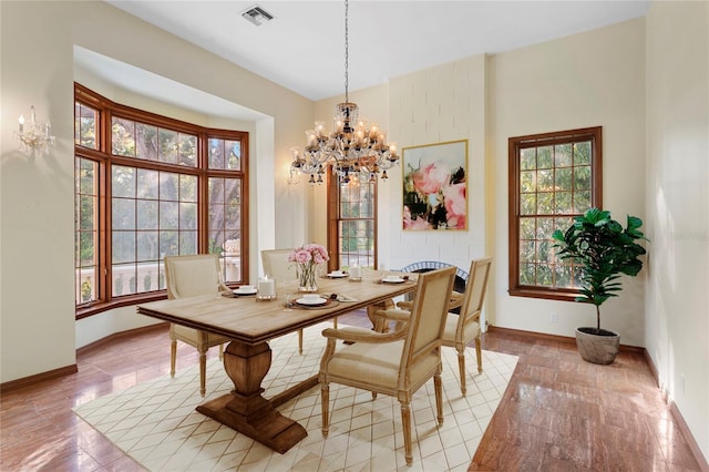 dining room featuring baseboards, visible vents, and a wealth of natural light