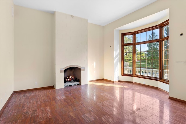 unfurnished living room with baseboards and a brick fireplace