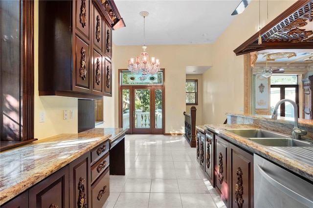 kitchen featuring a sink, dark brown cabinets, plenty of natural light, dishwasher, and hanging light fixtures