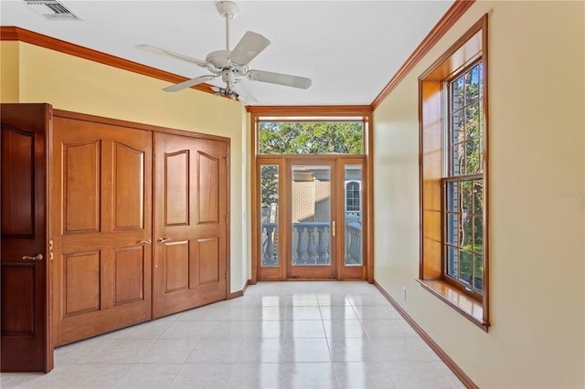 entrance foyer featuring light tile patterned floors, visible vents, baseboards, ornamental molding, and a ceiling fan