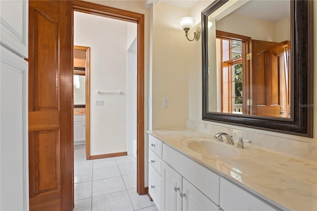 bathroom with baseboards, tile patterned flooring, and vanity