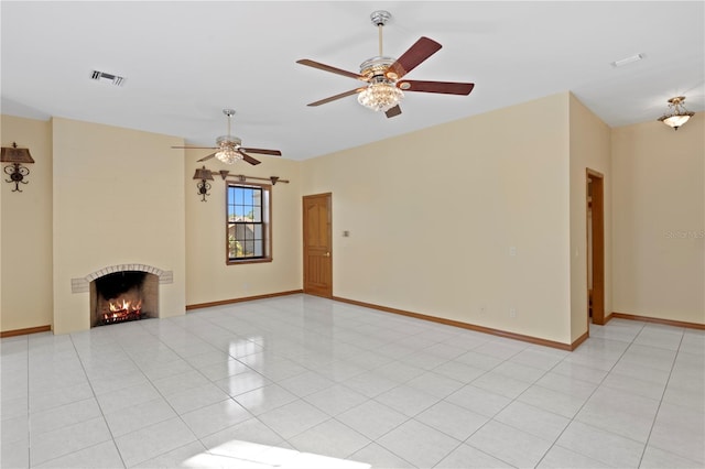 unfurnished living room featuring a fireplace, light tile patterned flooring, a ceiling fan, visible vents, and baseboards